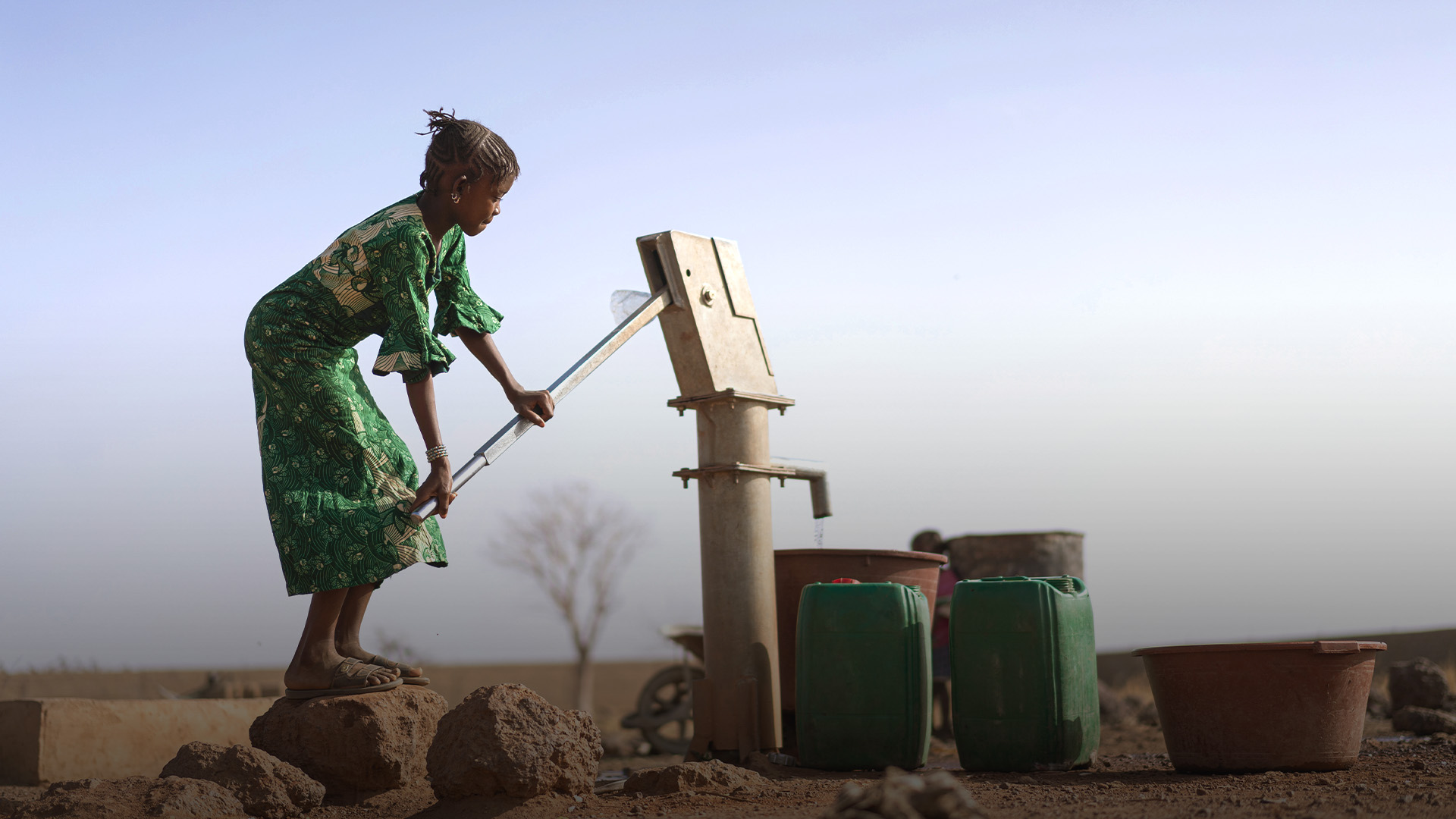 girl pulling water from a well