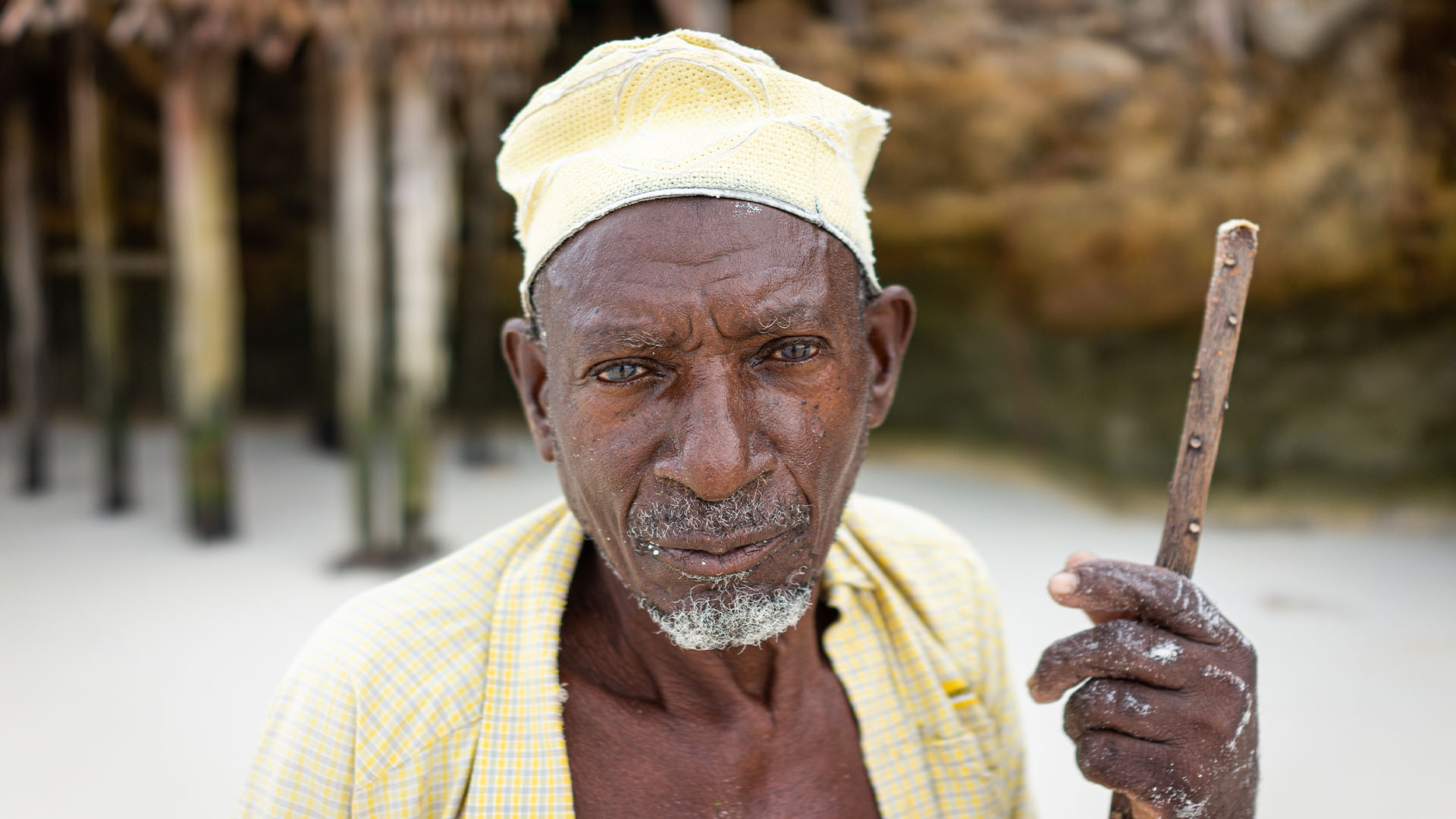 Elderly African man holding stick